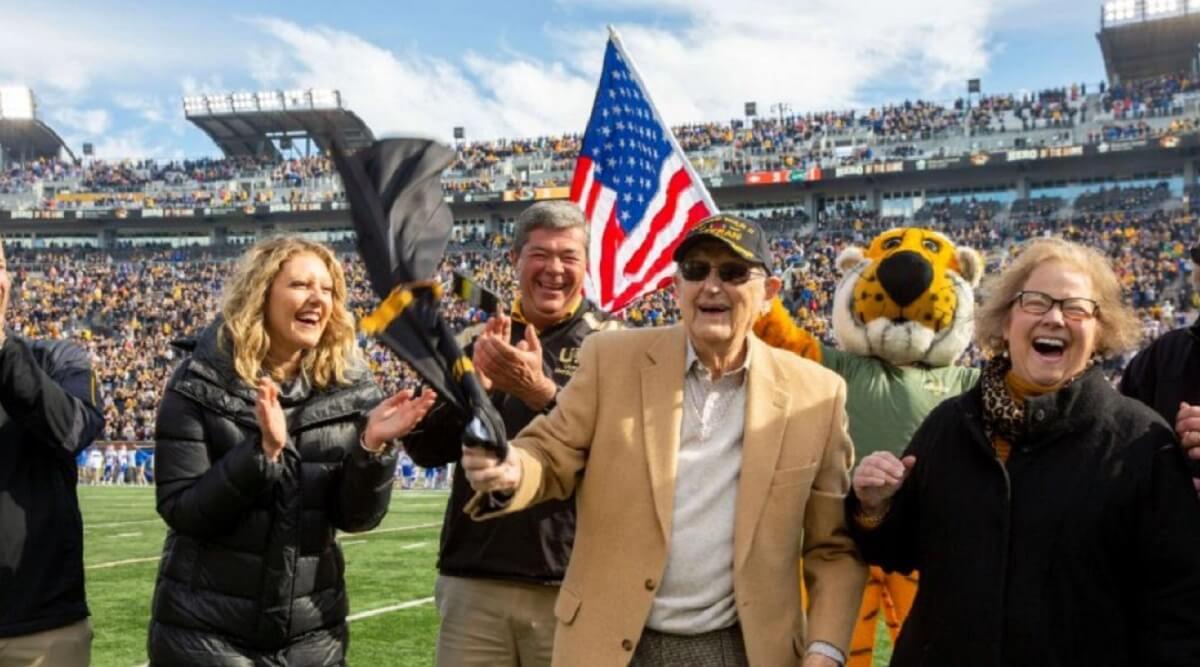 Football fans cheer for major Harvey B. Young Jr.