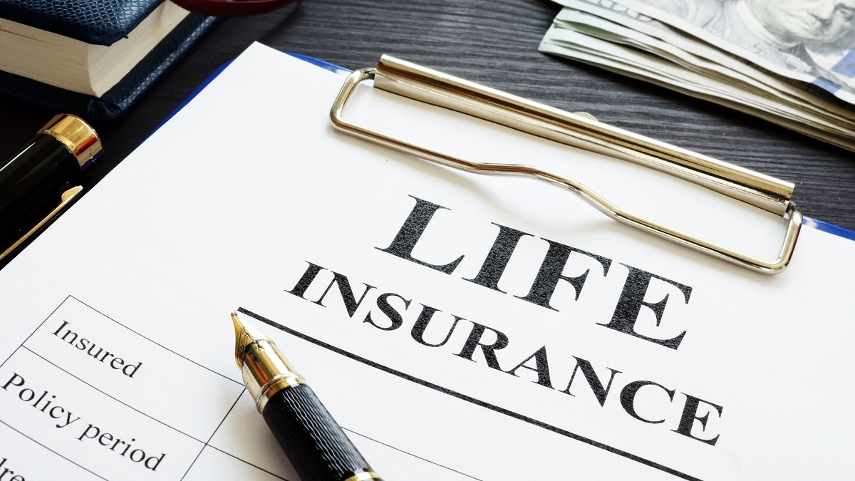 Life insurance papers on a clipboard underneath a pen.